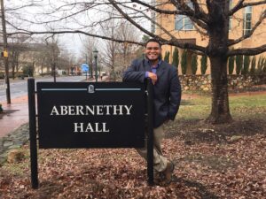 man standing in front of a sign that reads Abernathy Hall